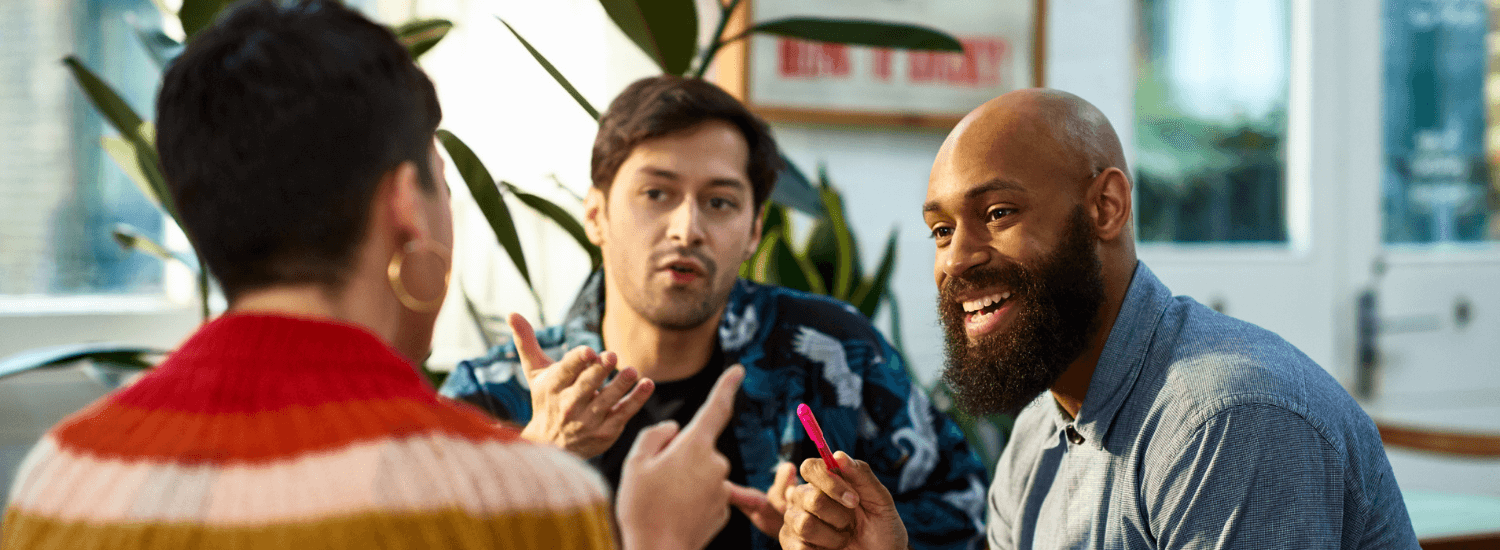 Group of coworkers smiling as they discuss an idea